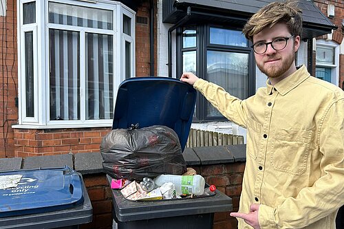 Joe standing by full bins